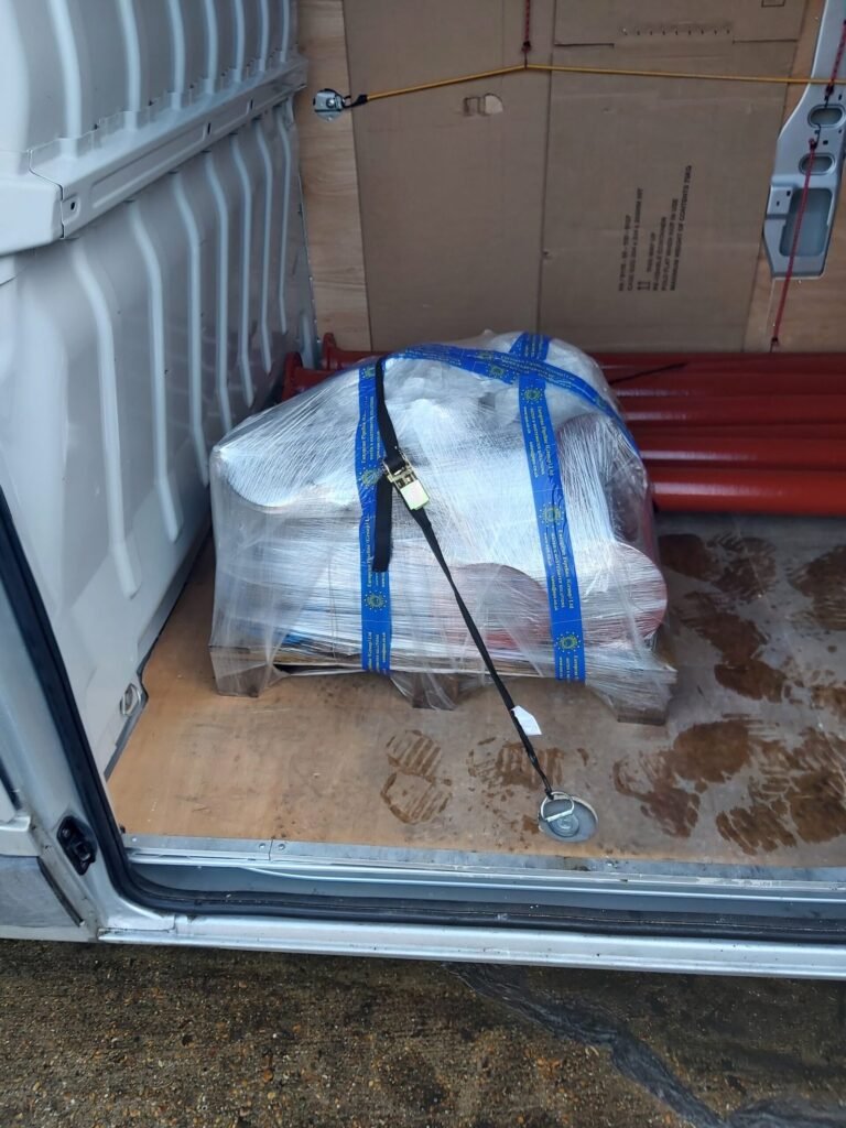 Mixed metal goods stacked and strapped for courier delivery