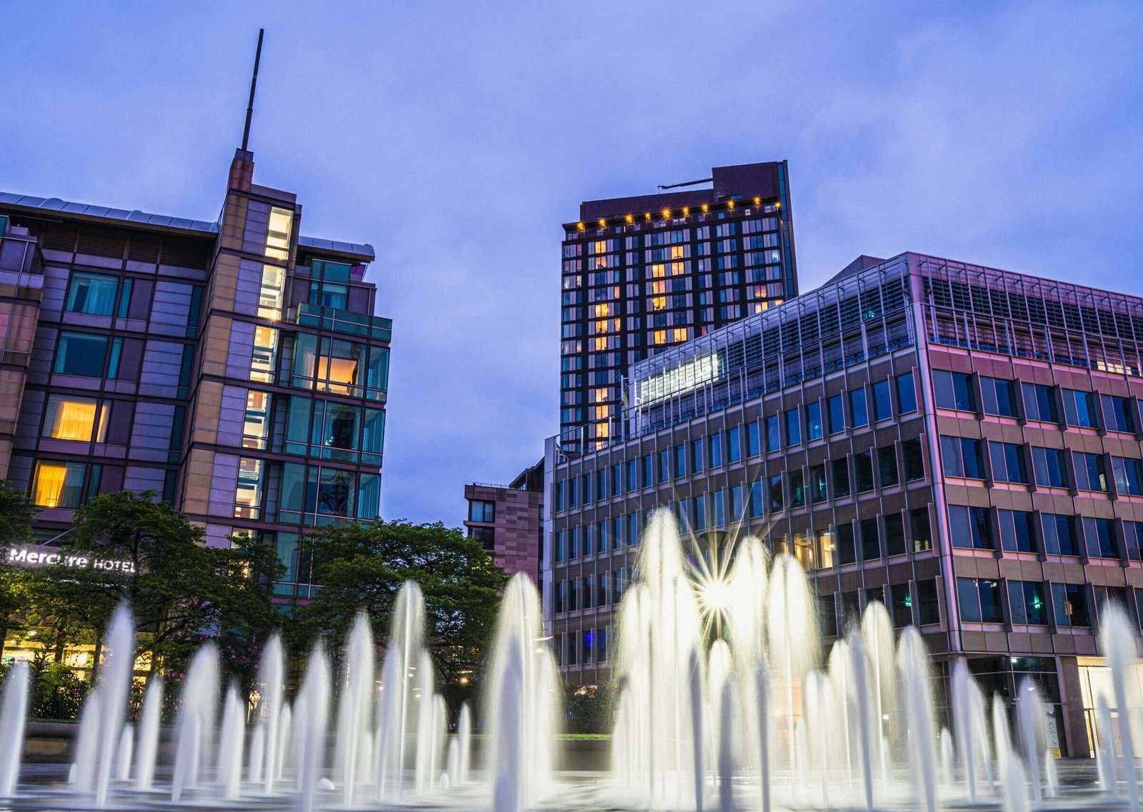 Night view of Sheffield city center with modern buildings and illuminated fountains capturing urban beauty.