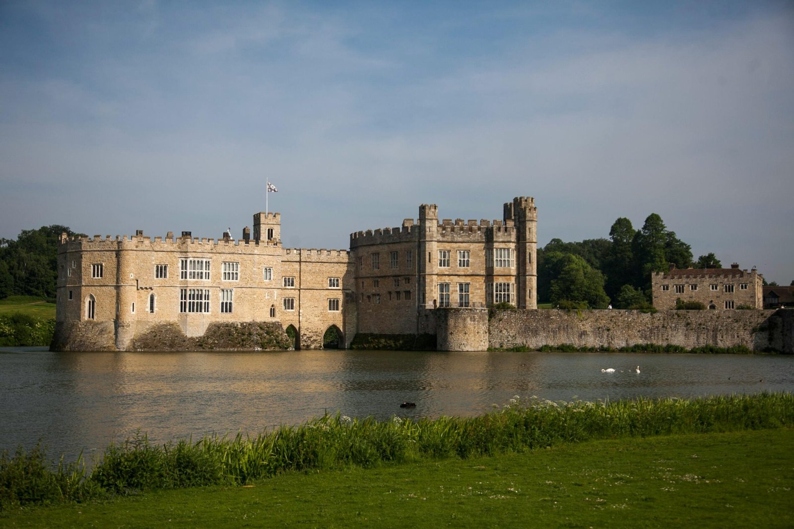 Beautiful view of the historic Leeds Castle surrounded by water under a clear sky.