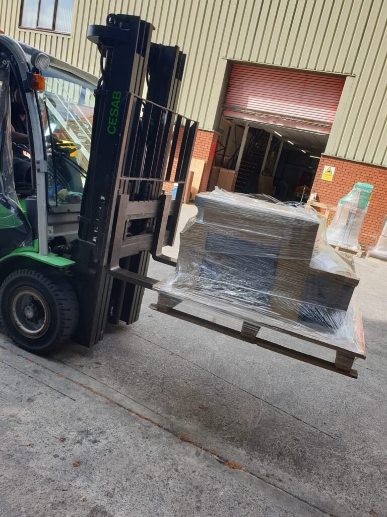 Forklift unloading large heavy pallet from courier van